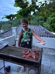 a man is cooking meat on a grill at ISLA tress Bonita Wellness Escape Island in San Vicente
