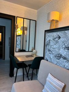 Habitación con mesa, espejo y sofá. en Le Chanzy Proche des Thermes et de la Gare, en Rochefort