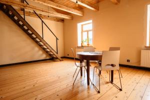 ein Esszimmer mit Tisch und Stühlen und einer Treppe in der Unterkunft Inovatorių slėnis/ Innovators' valley in Antalieptė + 21 Fotos