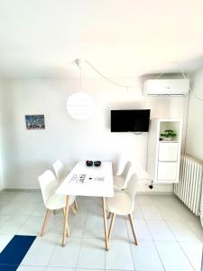 ein weißes Esszimmer mit einem weißen Tisch und Stühlen in der Unterkunft Apartamento Zodiac AB 2 C in Lloret de Mar + 7 Fotos