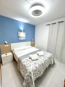 ein Schlafzimmer mit einem Bett und einer blauen Wand in der Unterkunft Apartamento Zodiac AB 2 C in Lloret de Mar