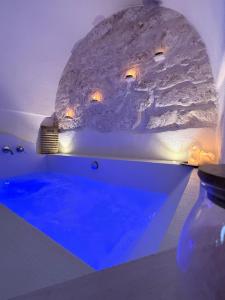 una vasca da bagno in una stanza con parete di roccia di Dimore i Messapi Suites Diffuse a Ceglie Messapica
