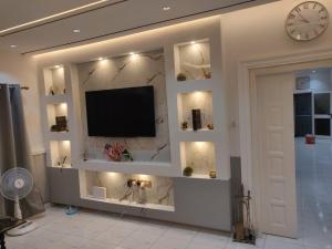 a living room with a tv on a wall at Ghanastays 2 in Accra