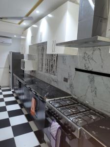 a kitchen with a stove and a checkered floor at Ghanastays 2 in Accra