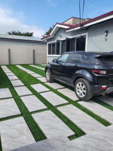 a black car parked in front of a house at Ghanastays 2 in Accra