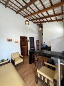 a living room with a table and chairs at Chalé aconchegante no Prado - Ar, Wi-Fi e ótima localização in Prado +2 photos