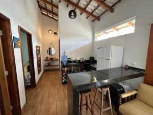 a kitchen with a counter top and a refrigerator at Chalé aconchegante no Prado - Ar, Wi-Fi e ótima localização in Prado