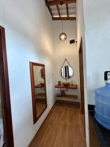 a hallway with a mirror and a sink at Chalé aconchegante no Prado - Ar, Wi-Fi e ótima localização in Prado