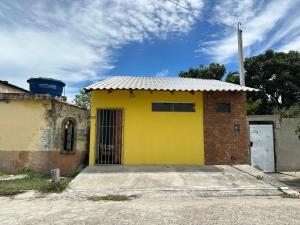 a yellow building with a door on the side of it at Chalé aconchegante no Prado - Ar, Wi-Fi e ótima localização in Prado
