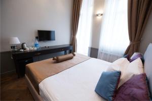 um quarto de hotel com uma cama e uma televisão em Seven Rooms Boutique Hotel em Baku