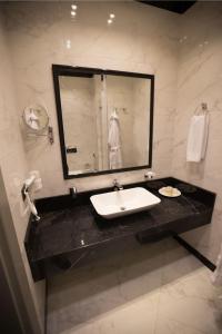 uma casa de banho com um lavatório e um espelho em Seven Rooms Boutique Hotel em Baku