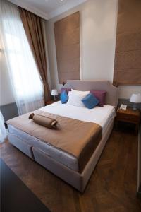 a bedroom with a large bed with blue pillows at Seven Rooms Boutique Hotel in Baku
