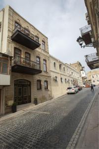 a cobblestone street in a city with buildings and a car at Seven Rooms Boutique Hotel in Baku