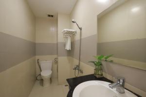 a bathroom with a sink and a toilet and a mirror at Smile hotel in Danang +22 photos