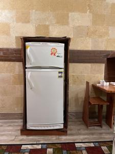 a white refrigerator is sitting next to a table at Baraa house in Cairo
