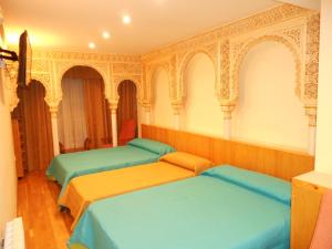 ein Zimmer mit drei Betten in einem Zimmer in der Unterkunft Martin House & Granada in Granada