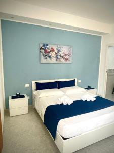 una camera da letto con un letto grande con una parete blu di B&B La CYCAS a San Vito lo Capo