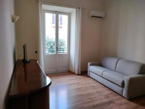 a living room with a couch and a sliding glass door at La casa di Norma- Anzio Centro 4 posti letto in Anzio
