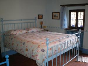 a bedroom with a bed with a floral bedspread at Agriturismo Podere Torre in Greve in Chianti