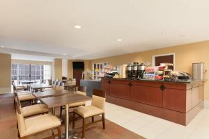 a restaurant with a table and chairs and a kitchen at Hawthorn Extended Stay by Wyndham College Station in College Station