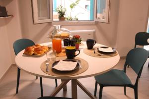 a table with a breakfast of croissants and orange juice at La Pura Vida in Castelsardo