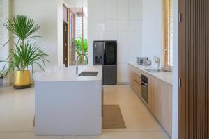 a kitchen with a white counter and a refrigerator at Adika Beach Villas in Chaloklum