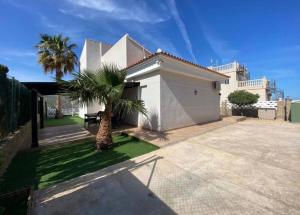 a house with a palm tree in front of it at Casa Violetta in Alicante