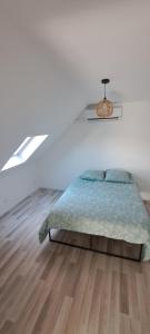 a white bedroom with a bed and a wooden floor at maison ville in Chauny +3 photos