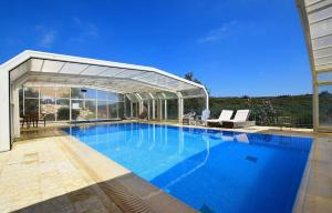 a large blue swimming pool with a pavilion at וילה אלסוס - וילה מהממת עם בריכה פרטית, ג'קוזי ונוף in Shetula +35 photos