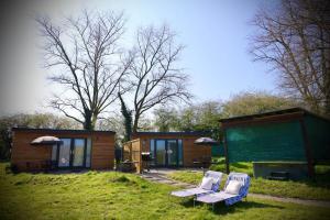 a couple of chairs sitting outside of a tiny house at Rocklands Retreat in Rockland Saint Peter +8 photos