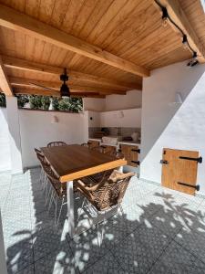a dining room with a wooden table and chairs at Casa Palmerita a 7 minutos andando de una playa de aguas cristalinas in Teulada