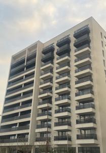 a large white building with balconies at ABE Apartment in Craiova
