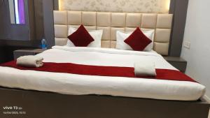 a large bed with red and white blankets and pillows at Hotel Shanti Niketan By Nexottel in Deoghar