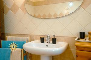 a bathroom with a white sink and a mirror at Casa dell'Artista - Ampio appartamento in zona tranquilla e centrale in Iglesias