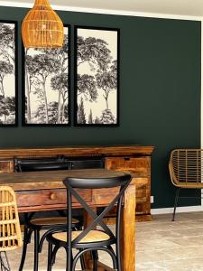 a dining room with green walls and a wooden table and chairs at Casa Eva Maria in Patrimonio