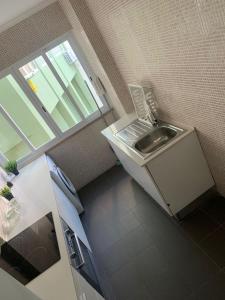 Una pequeña cocina con fregadero y ventana. en Central Lisbon rooms, best location for tourists, en Lisboa 11 fotos más