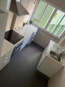 cocina con encimeras blancas y ventana grande en Central Lisbon rooms, best location for tourists, en Lisboa