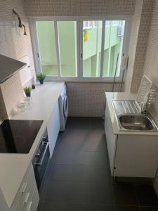 una pequeña cocina con fregadero y lavavajillas en Central Lisbon rooms, best location for tourists, en Lisboa