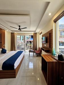 a bedroom with a bed and a television in a room at Luxeevista - By Navodayans in Dharamshala