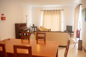 a living room with a table and a couch at Casa do Cédro in Vila Franca do Campo