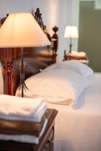 a bed with a table with a lamp on it at Casa do Cédro in Vila Franca do Campo