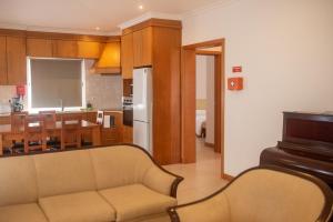 a living room and kitchen with a couch and a table at Casa do Cédro in Vila Franca do Campo
