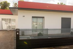a white house with a fence in front of it at Casa do Cédro in Vila Franca do Campo