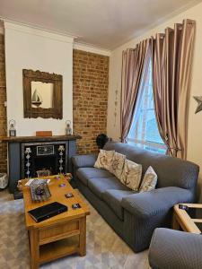 a living room with a couch and a table at Driftwood Apartments Broadstairs in Broadstairs