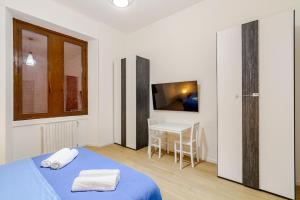 een slaapkamer met een bed, een tafel en een televisie bij Casa Marelli in Sesto San Giovanni