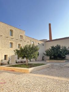 a building with a tree in front of it at Luxury Penthouse with 2 Pools in a Monastery in Tavira