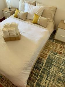 a white bed with pillows and a tray of towels at Sobreira Stone Cottage in Peso da Régua