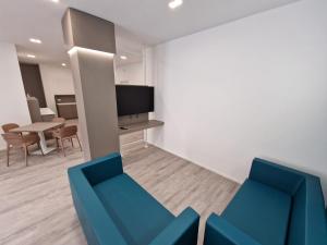 a living room with two blue chairs and a tv at B&B L' Oasi in Chiatona