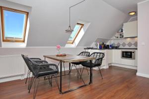 a kitchen and dining room with a table and chairs at Villa Seepferdchen Wohnung 09 in Kühlungsborn +15 photos