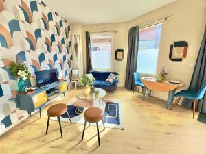 a living room with a couch and a table and chairs at T2 Cosy Centre Ville Amiens - Rez-de-chaussée in Amiens